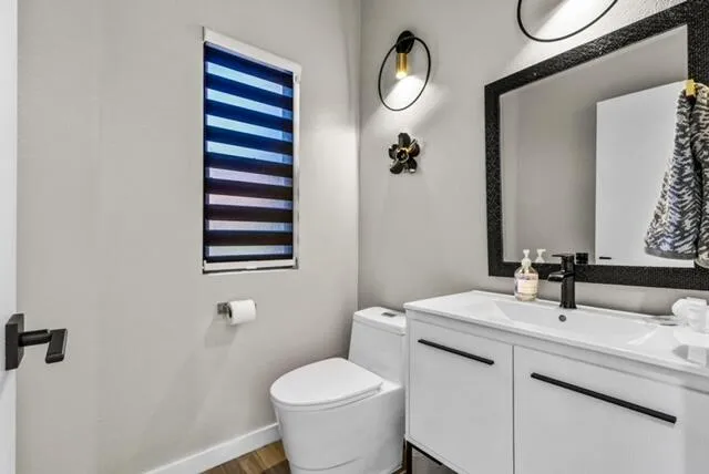 a bathroom with a sink mirror vanity and toilet