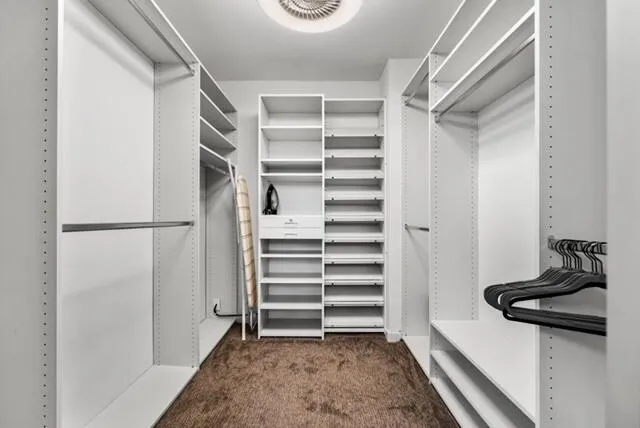 a view of walk in closet with empty racks