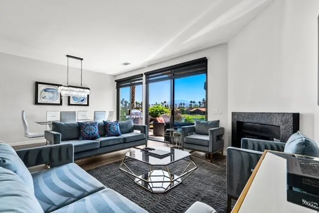 a living room with furniture fireplace and a large window
