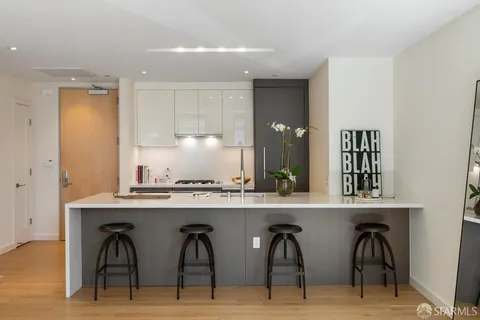 a kitchen with stainless steel appliances granite countertop a table and chairs in it