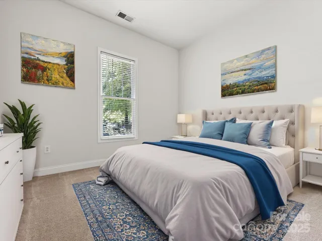 a bedroom with bed and painting on the wall