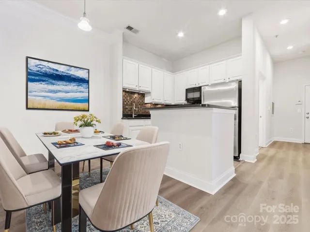 a kitchen with a table chairs refrigerator and microwave