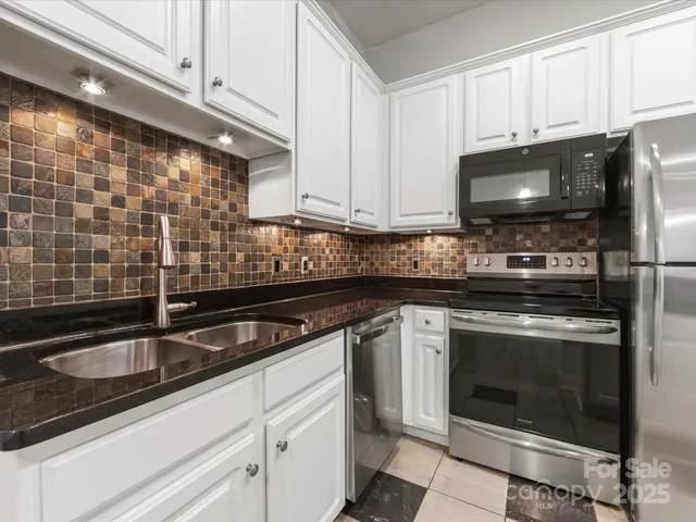 a kitchen with granite countertop a stove sink and microwave