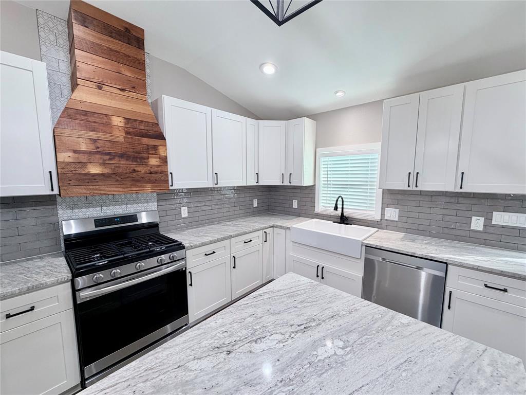 710 North Rusk Street Weatherford, TX 76086 - Photo 4 of 30 tile backspalsh all the way t ceiling, beautfil cedar wood trim on vent hood, 5 burner gas range.