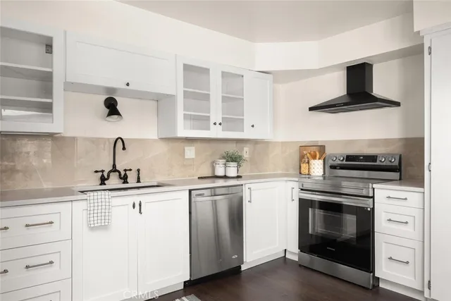a kitchen with white cabinets stainless steel appliances and sink