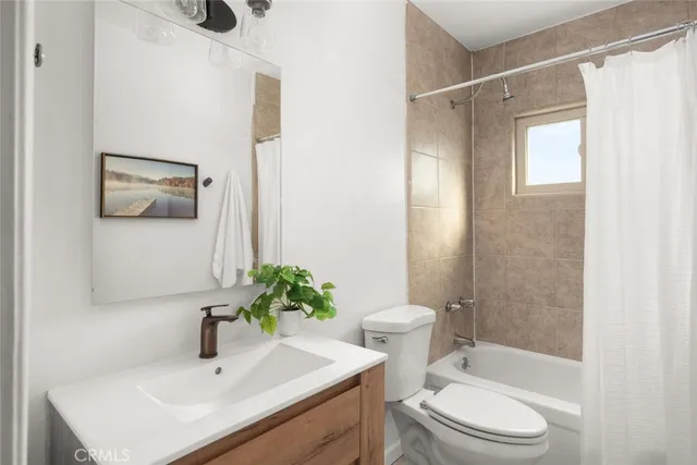 a white house with a small yard and wooden fence