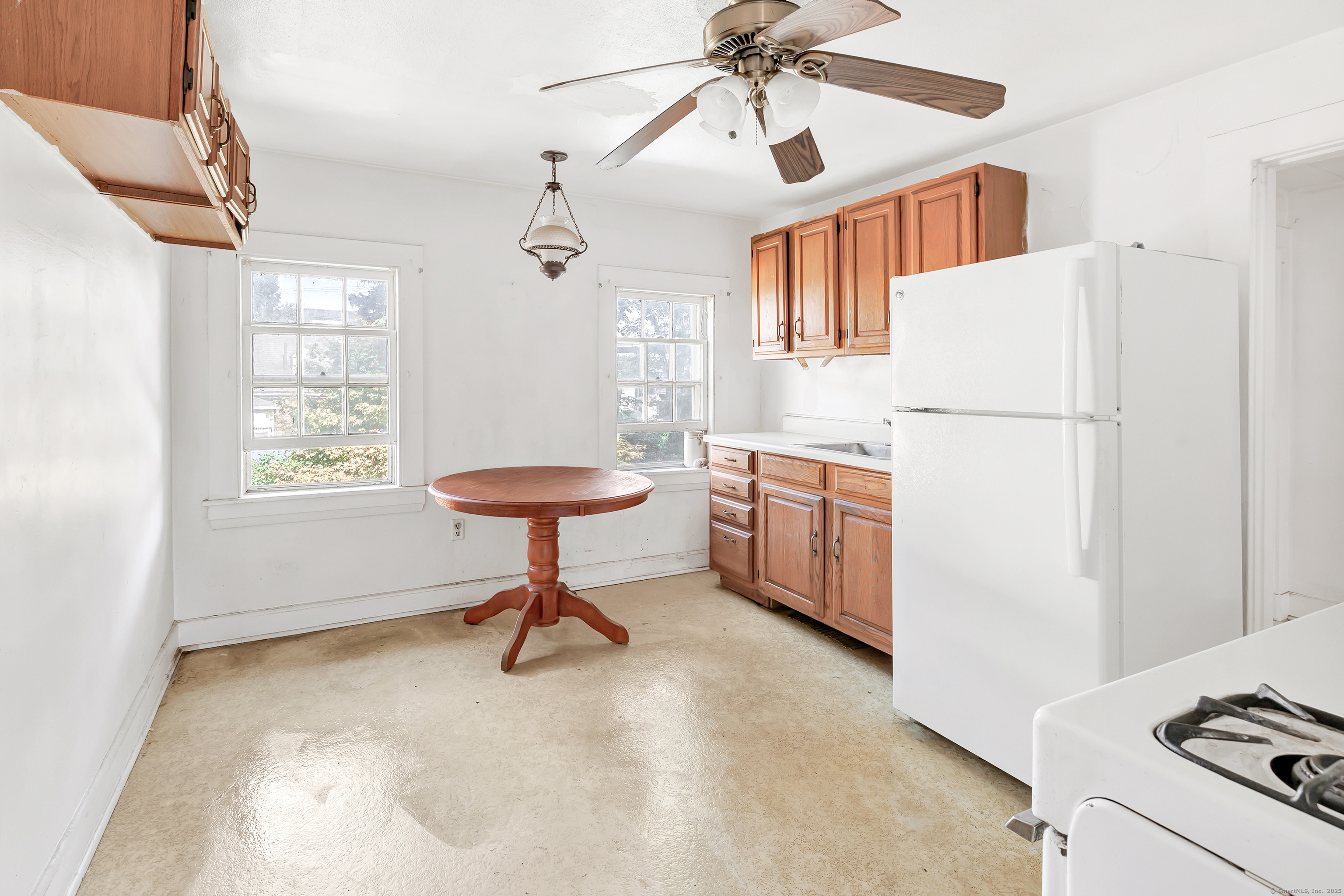 22 Sims Street Bridgeport, CT 06604 - Photo 15 of 22 a kitchen with a refrigerator a stove cabinets and a dining table