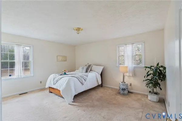 a spacious bedroom with a bed and a window