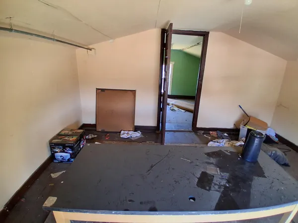 an empty room with hard wood floor and window