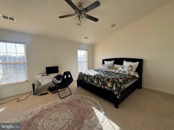 an empty room with wooden floor mirror and windows