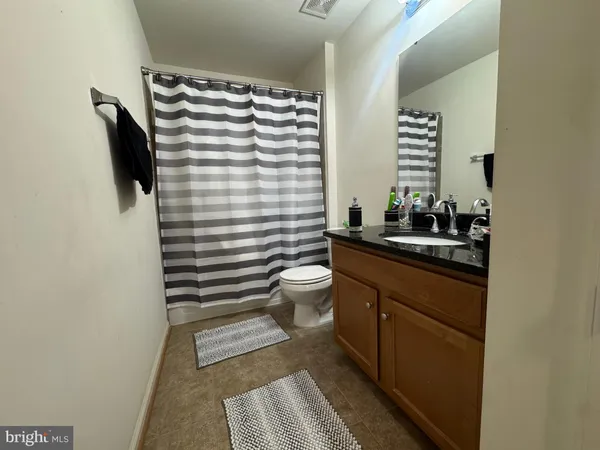 an empty room with wooden floor closet and windows