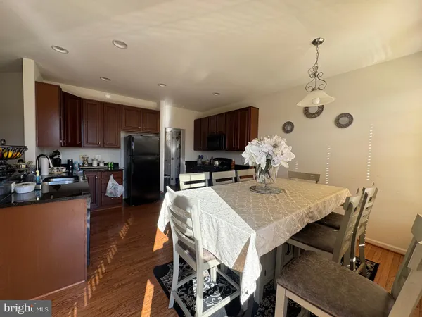 a kitchen with stainless steel appliances a stove a sink dishwasher and a microwave with wooden floor