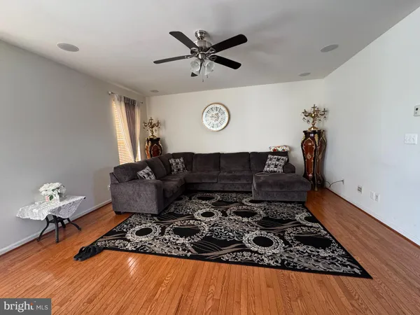 a living room with couch and a clock on the wall