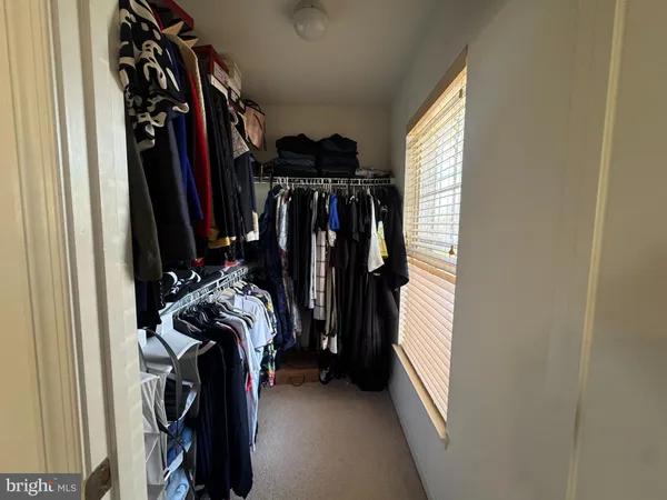 a view of walk in closet with clothes