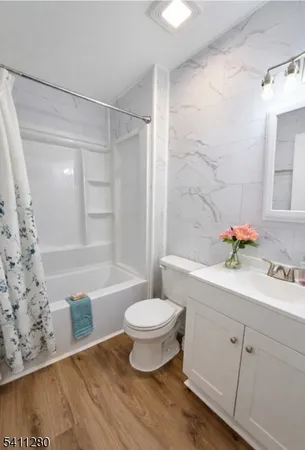 a bathroom with a sink toilet a mirror and shower