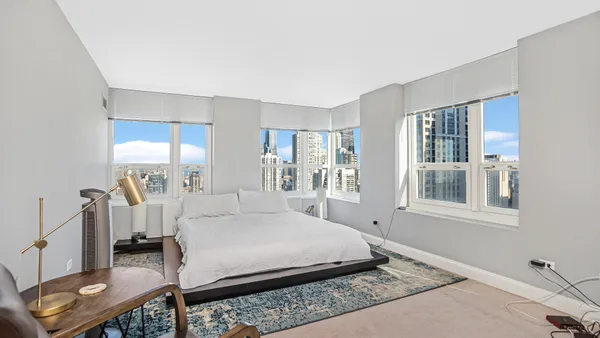 a bedroom with a bed a mirror and a window