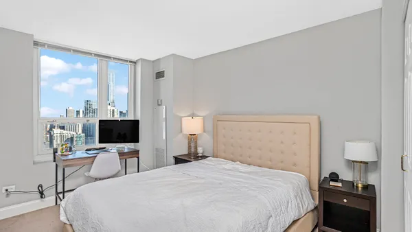 a bedroom with a bed tv and a window