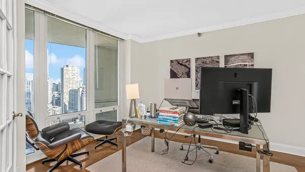 a view of a workspace with furniture and a window
