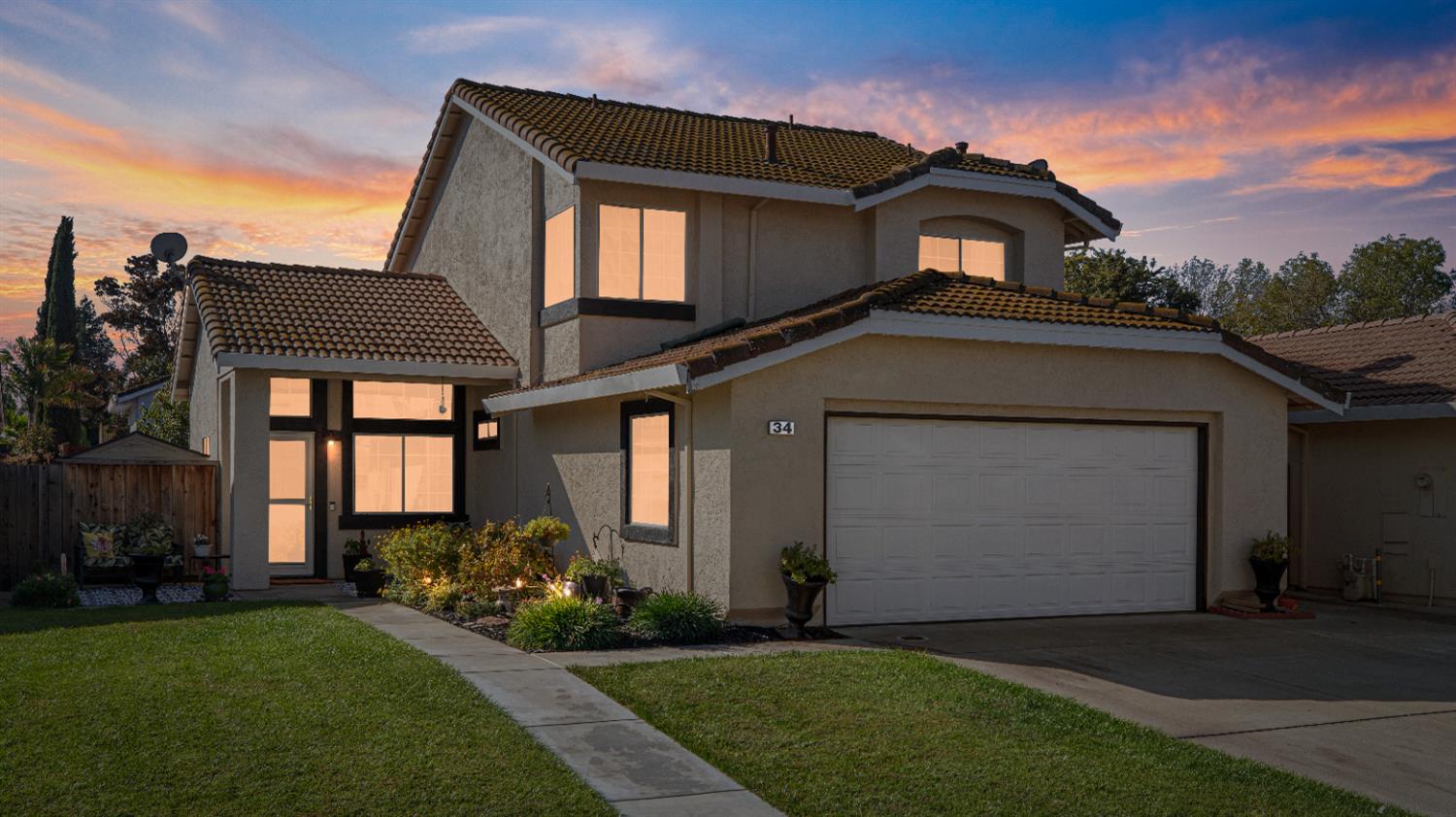 a front view of a house with a garden and plants