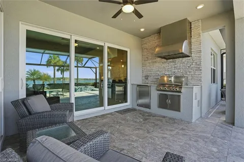 a view of a patio with couches and chairs under an umbrella
