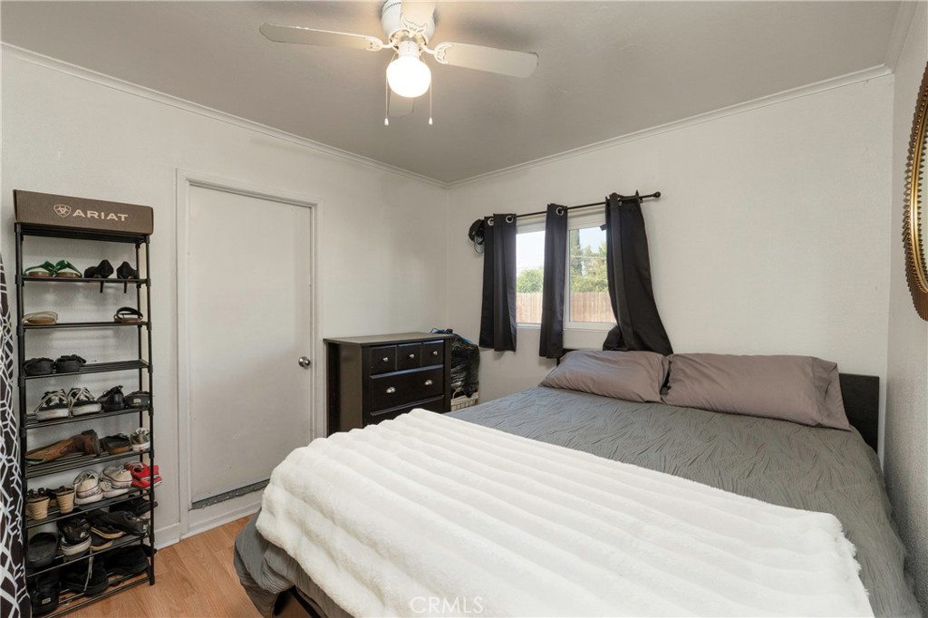 11661 Valverda Avenue Riverside, CA 92505 - Photo 27 of 39 a bedroom with a bed and a bookshelf with wooden floor