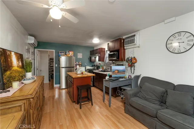 a living room with furniture a flat screen tv and kitchen view