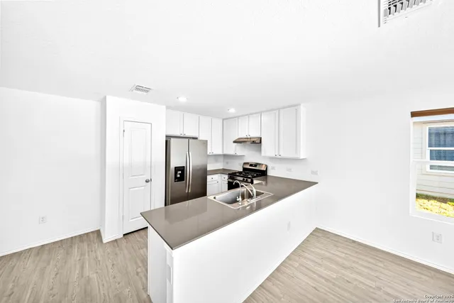 a kitchen with a stove a refrigerator and a sink