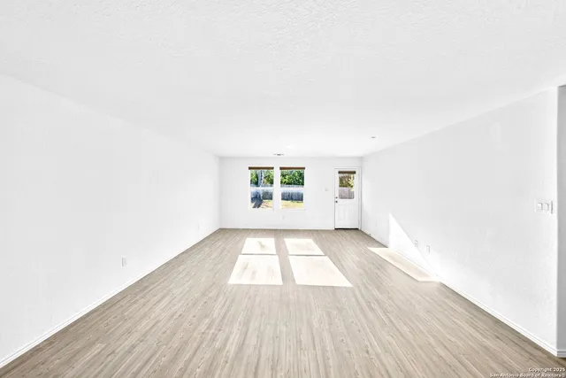 a view of kitchen and hall with wooden floor