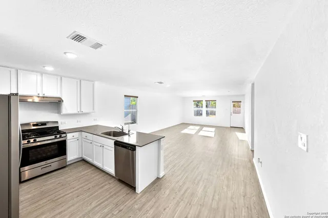 a kitchen with kitchen island a sink appliances and cabinets