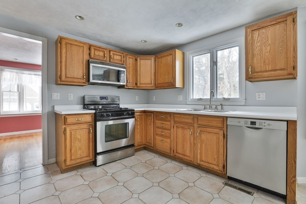 1 Deer Path Lane Mansfield, MA 02048 - Photo 11 of 31 a kitchen with stainless steel appliances granite countertop a stove a sink and a microwave