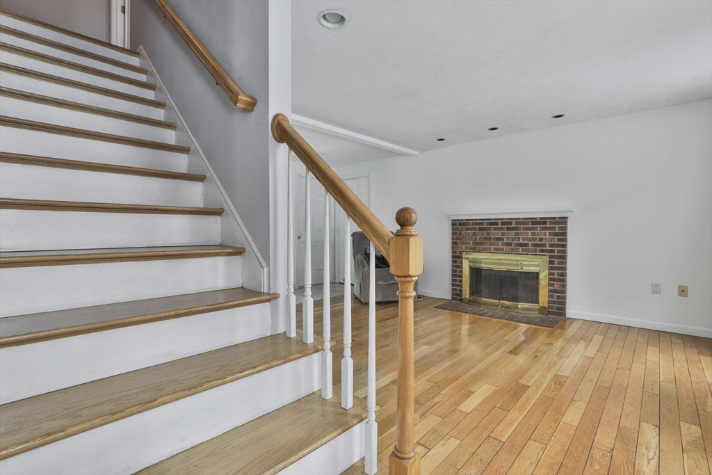 1 Deer Path Lane Mansfield, MA 02048 - Photo 17 of 31 a view of staircase with wooden floor and a fireplace