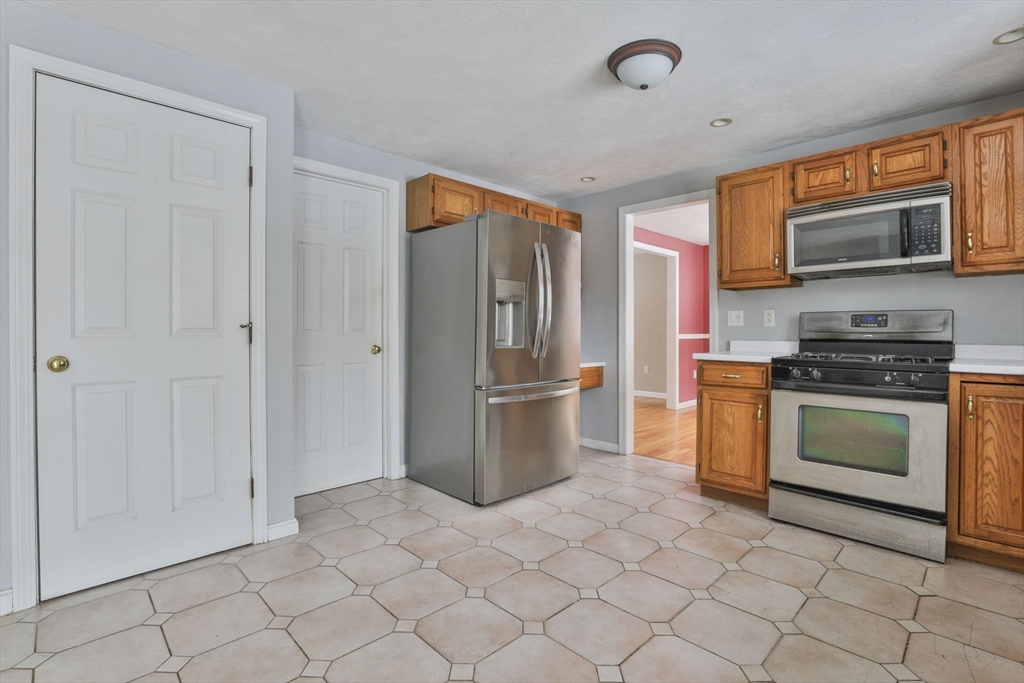 1 Deer Path Lane Mansfield, MA 02048 - Photo 10 of 31 a kitchen with stainless steel appliances granite countertop a refrigerator and a stove top oven