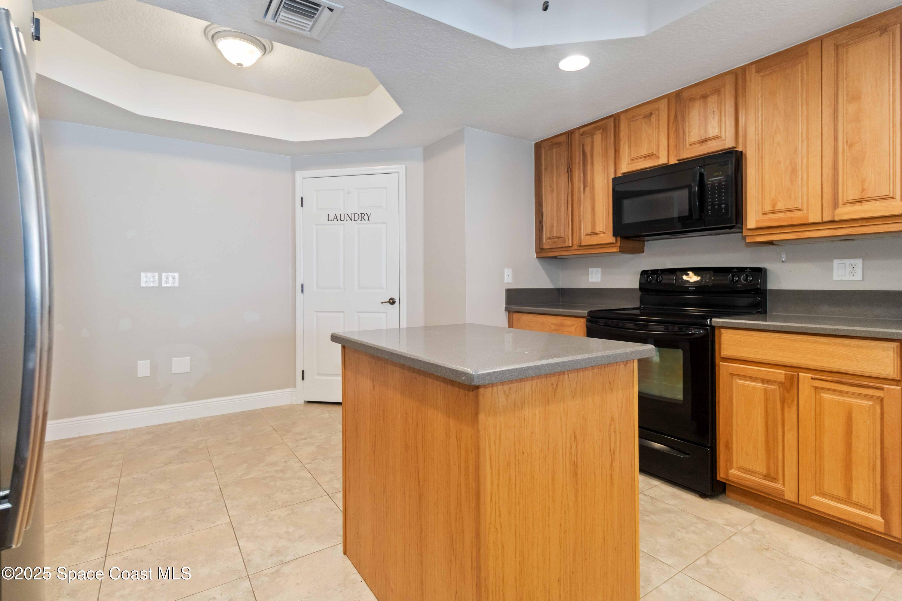 134 Starboard Lane, Unit 404 Merritt Island, FL 32953 - Photo 11 of 30 a kitchen with stainless steel appliances granite countertop a stove a sink and a refrigerator