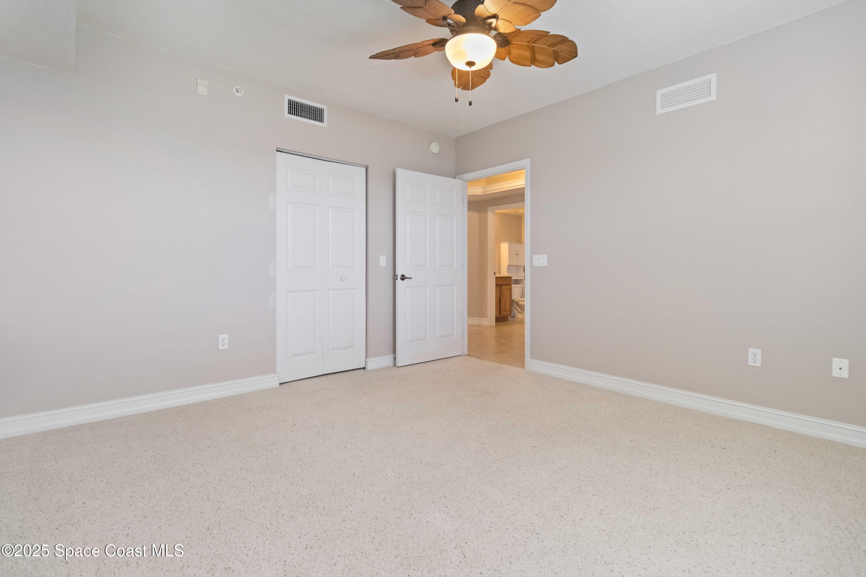 134 Starboard Lane, Unit 404 Merritt Island, FL 32953 - Photo 15 of 30 en empty room with a chandelier fan and windows