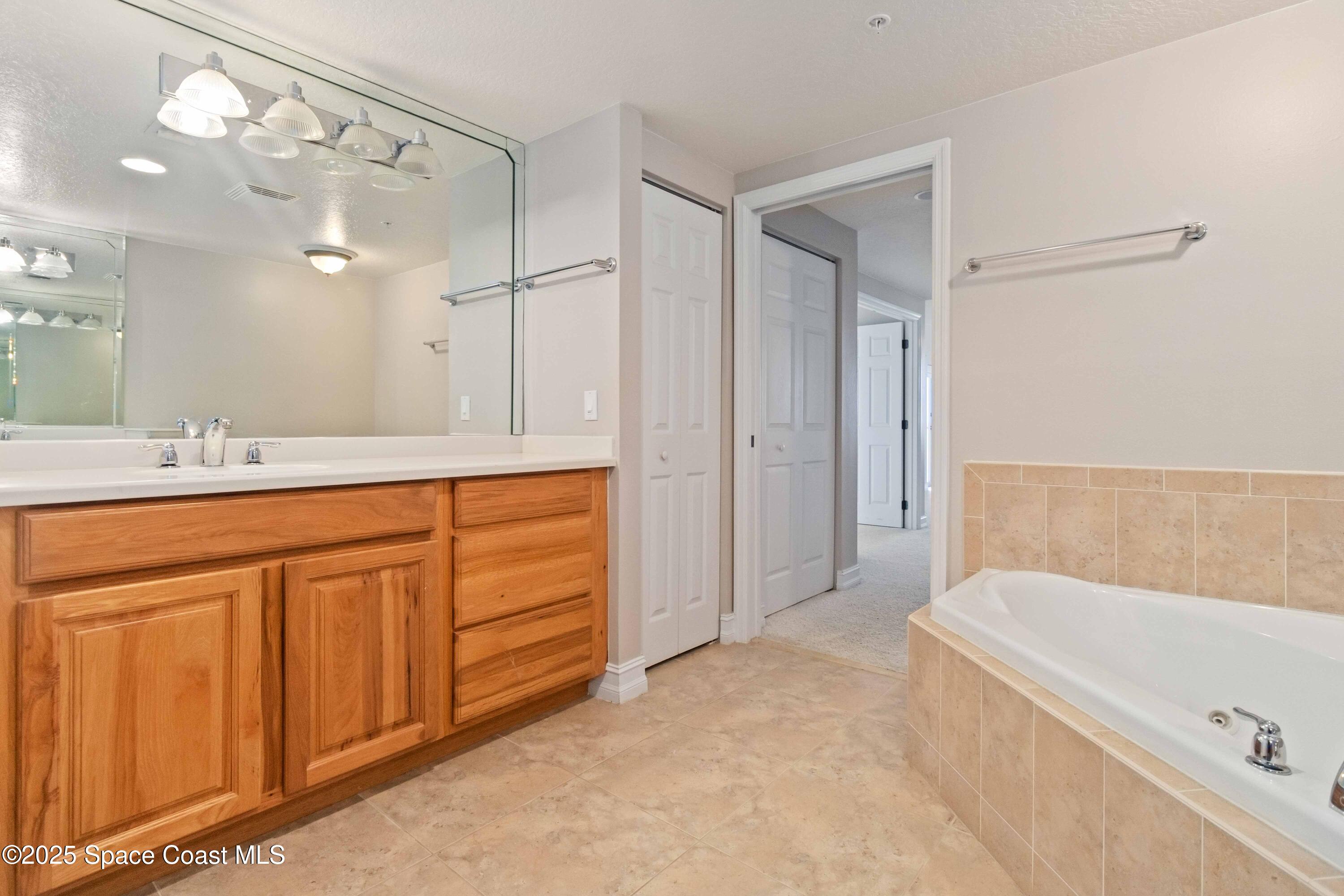 134 Starboard Lane, Unit 404 Merritt Island, FL 32953 - Photo 21 of 30 a spacious bathroom with a tub sink and mirror