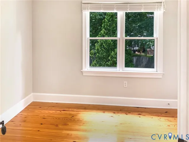 wooden floor in an empty room with a window
