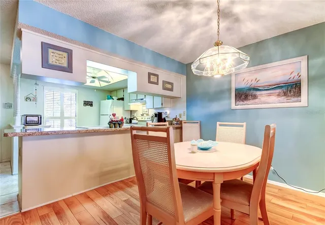 a view of a dining room with furniture a chandelier and wooden floor