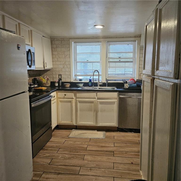 4880 Ben Hill Road Atlanta, GA 30349 - Photo 19 of 48 a kitchen with granite countertop a sink stainless steel appliances and cabinets