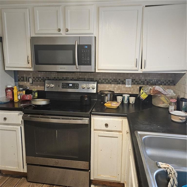 4880 Ben Hill Road Atlanta, GA 30349 - Photo 20 of 48 a kitchen with granite countertop a stove and a sink