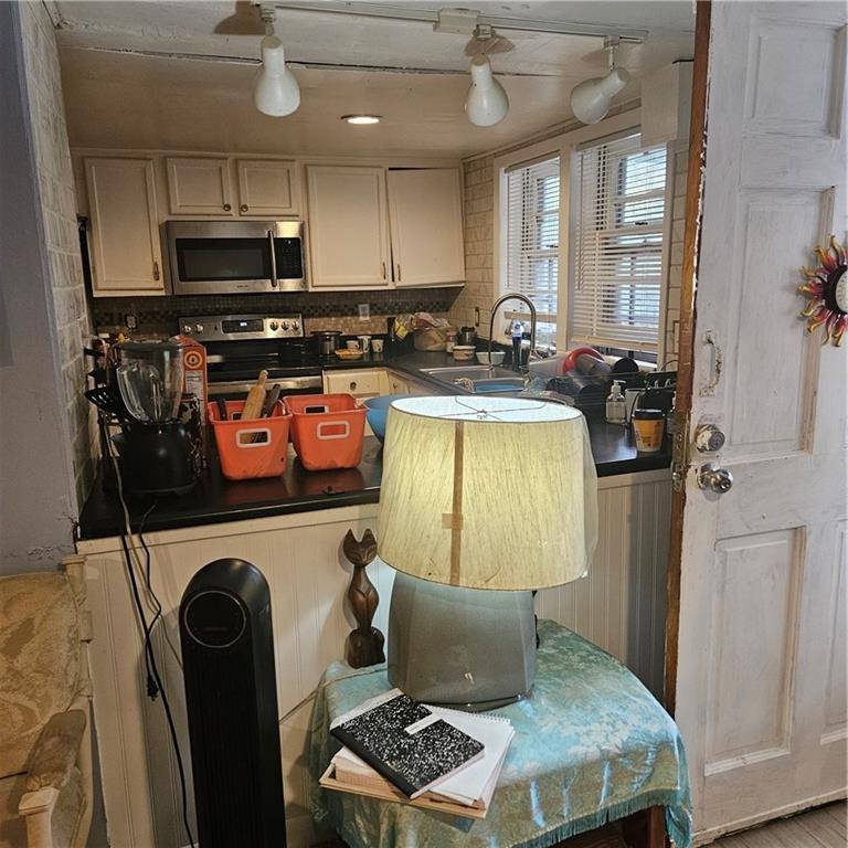 4880 Ben Hill Road Atlanta, GA 30349 - Photo 22 of 48 a kitchen with stainless steel appliances granite countertop a refrigerator stove top oven a sink and dishwasher