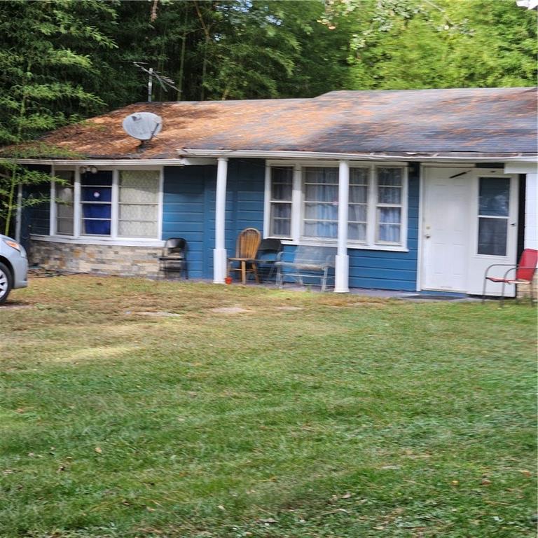 4880 Ben Hill Road Atlanta, GA 30349 - Photo 39 of 48 a front view of a house with a garden and porch