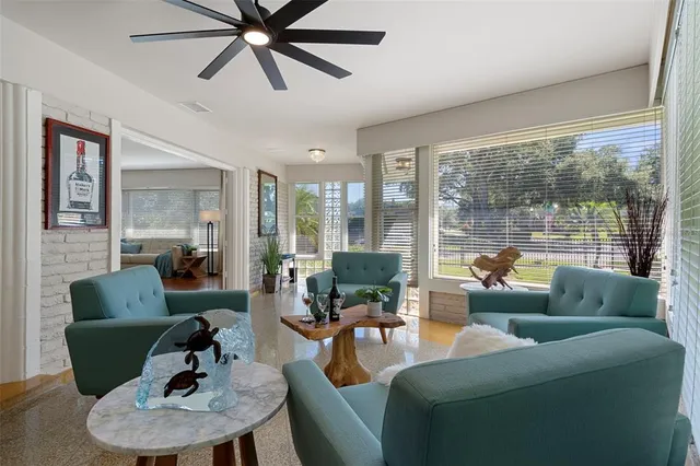 a backyard of a house with table and chairs under an umbrella