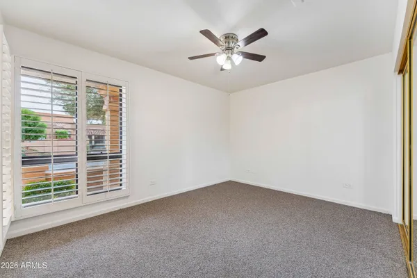 an empty room with a ceiling fan and a window