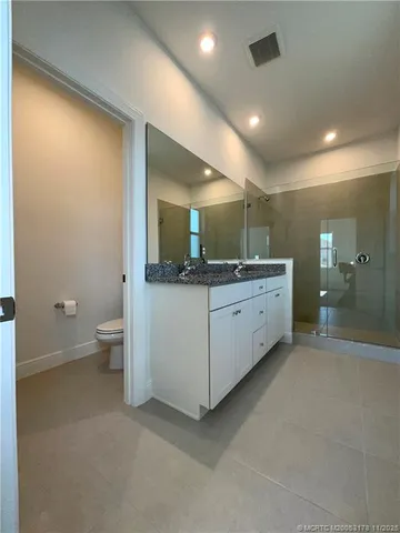 a spacious bathroom with a granite countertop sink and a mirror