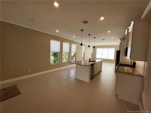 a view of kitchen with kitchen island stainless steel appliances counter space and a window
