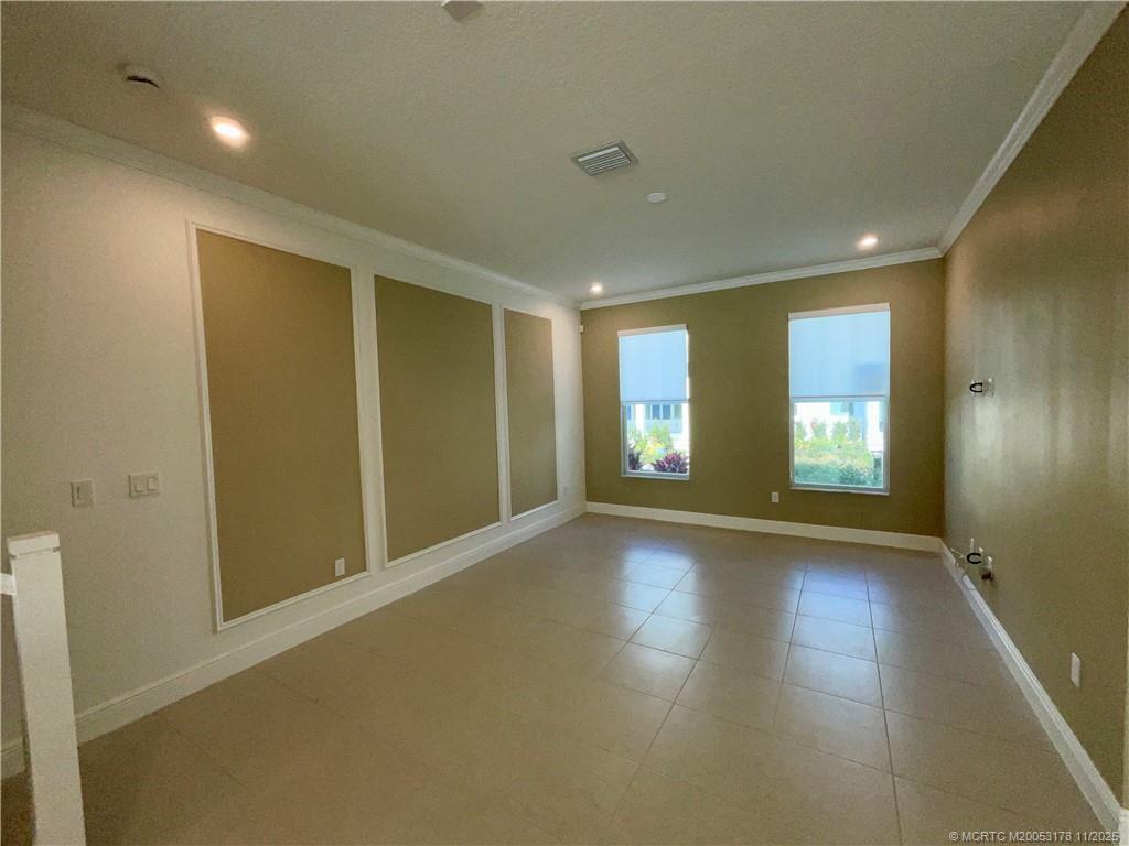 860 Southwest Bushel Trail Palm City, FL 34990 - Photo 8 of 25 a view of an empty room with wooden floor and a window
