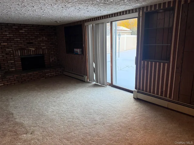 a view of an empty room with a fireplace and a window
