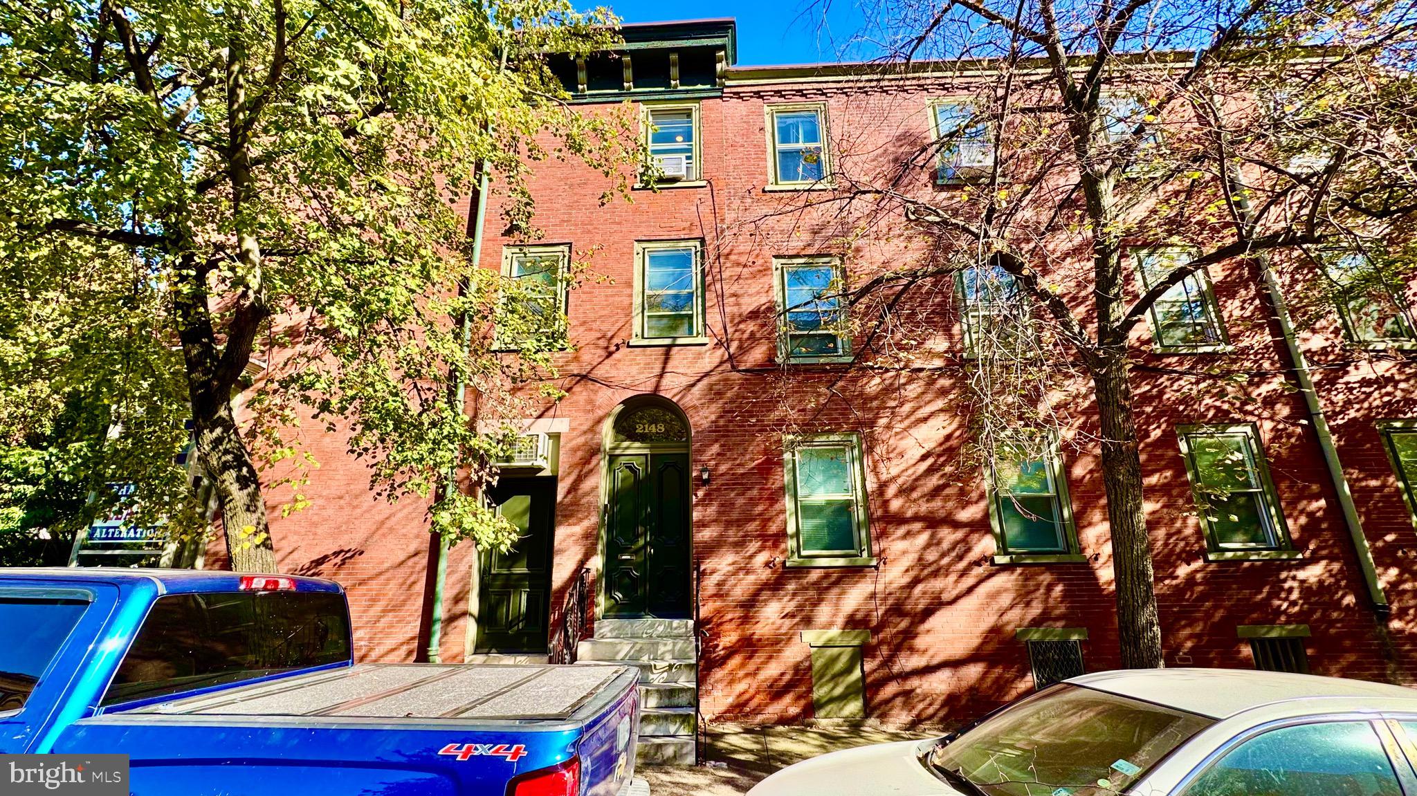 a backyard of a house with cars parked on road
