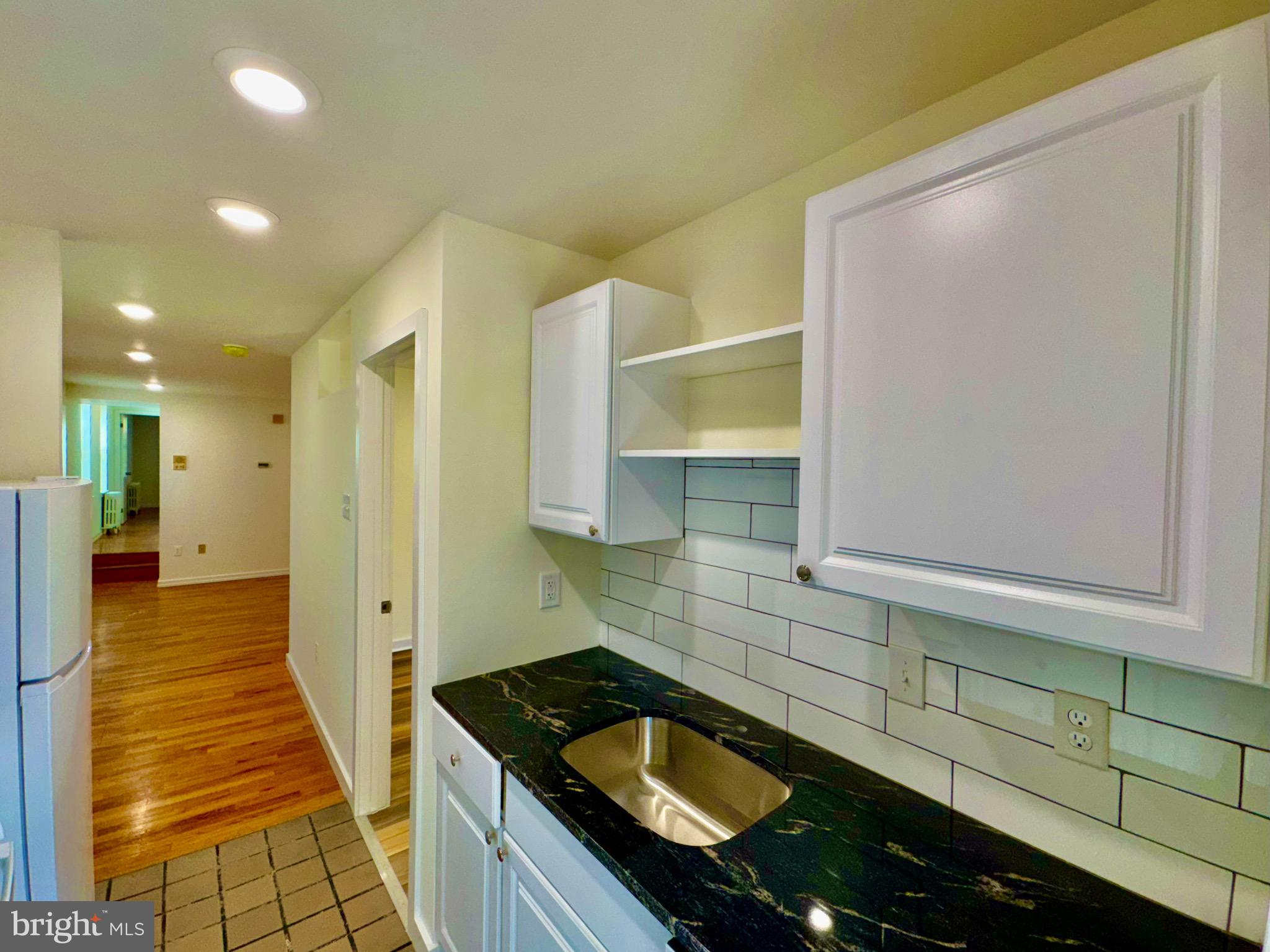 2148 Green Street, Unit 2 Philadelphia, PA 19130 - Photo 7 of 27 a kitchen with granite countertop a sink and cabinets