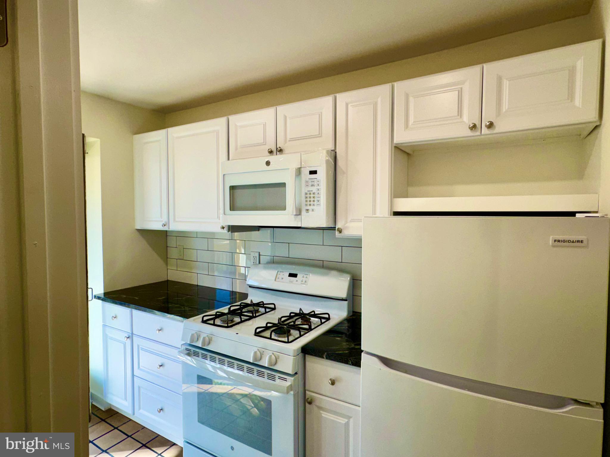 2148 Green Street, Unit 2 Philadelphia, PA 19130 - Photo 8 of 27 a kitchen with white cabinets and white appliances